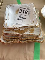 Stack of eight square Hammersley fine bone china plates with gold floral design and scalloped gold trims.