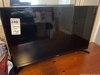 Front view of Samsung 32 inch television showing black bezel, screen, and feet on each side compatible with standard table placement.