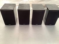 Four black Energy bookshelf speakers viewed from the front and angled, showing condition and branding.