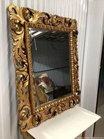 Front angle view of mirror leaning against storage unit wall