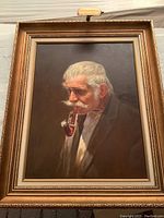 Front view of the original oil portrait painting of smoking gentleman in a gilded frame with brass light.