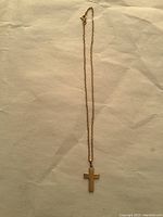 Full view of necklace with cross pendant laid flat