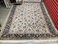 Full rug view rolled partially at one end showing overall pattern and fringe