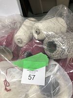 Yarn cones in plastic bag with pansy color cones and yarns viewed from side