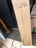 Closed cardboard box labeled 'Backdrop Stand Kit' with line drawing of stand and 'Lot 32' written in marker.