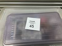 Clear plastic container with lid marked with auction lot number 45, showing the storage for beads and crafting materials.