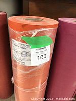 Photo of a full roll of rainbow orange butcher paper with MaxSold auction label.