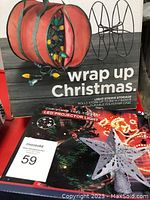 Photo showing Christmas light storage bag and LED projector tree top light box with star shape design.