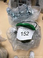 Two metal hanger holders each filled with multiple silver metal hangers equipped with clips for pants or skirts.