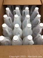 Box with 24 clear plastic utility jugs, each with white caps and handles, arranged standing upright