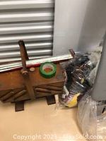 Vintage wooden sewing basket with compartments and metal corner protectors, handle visible.