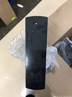 Top view of a single black foam shoe display piece showing a curved surface with a small hole at the top.