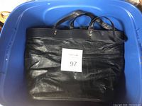 Large black tote handbag inside blue bin, showing overall size and condition