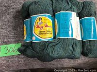 Three skeins of Mary Maxim brand yarn in green shades, marked with labels indicating double knitting and worsted weight. Photo shows texture and packaging intact.