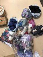 Overview of various yarn skeins and balls in multiple colors and textures on table surface.