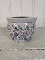 Front view of ceramic flower pot showing hand-painted flowers in pink, blue, and green.