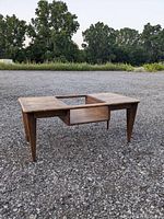 Full view of rectangular wooden coffee table with open center where glass top should be. Table shows wear and needs refinishing.