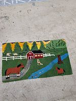 Full view of needlepoint rug showing overall farm scene with animals and landscape.