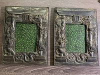 Front view of the pair of metal picture frames showing dragon repousse designs and 'Made in Japan' mark.