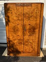 Frontal view of full cabinet showing double doors and burled walnut veneer