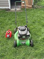 Front view of mower and gas can on lawn showing overall appearance and included items