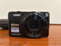 Front view of Nikon Coolpix 5700 digital camera showing lens, brand, model, and key features
