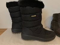 Side view of the black Olang winter boot showing the branding and sole details
