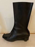 Side profile of the black leather boot showcasing the mid-calf height, squared toe, and block heel design.