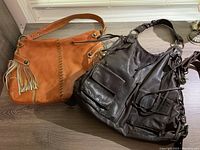 Both leather handbags show tan fringed Italian bag on the left and dark brown Sun Basics bag on the right.