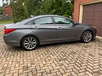 Side profile of grey 2011 Hyundai Sonata showing body lines, wheels and sunroof