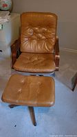 Full view of leather swivel chair and matching footstool