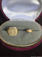 Both rings seated in open velvet box showing presentation setting