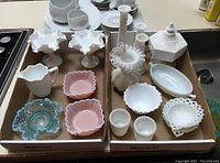 Seventeen pieces of milk glass and hobnail style candle holders, candy dishes, vases and jug, in two boxes, shown in overview from side angle