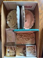 Tray with multiple shell-shaped jewelry holders and boxes containing pearl necklaces and earrings