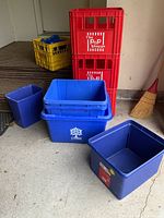Photo showing all crates and blue boxes from a distance in a garage setting.