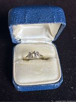 Close-up of gold ring in blue velvet box showing the ring's size and design