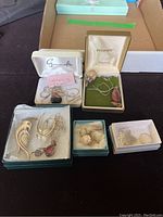 Lot of sterling silver jewelry including necklaces, chains, earrings, ring size 7.5, some stone pendants, all displayed with their boxes.