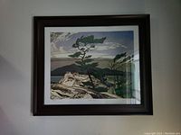 Full frontal view of framed art print hanging on wall