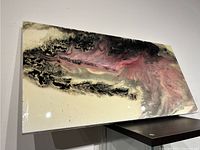 Side angle photo showing the abstract resin art on a wood board with visible glossy finish and swirling patterns.