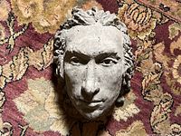 Top view of the concrete head wall hanging showing facial details and hair texture.