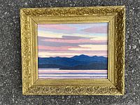 Full view of landscape painting in ornate gold frame on pavement