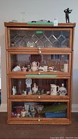 Front view showing all four stacking sections with glass doors and porcelain knobs.