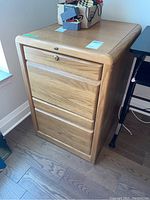 Full view of the wood file cabinet showing two drawers and natural wood finish.