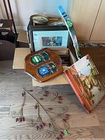 Boxes and frames including oval and rectangular frames, assorted prints, and decorative items on floor.