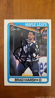 Front of signed Brad Marsh hockey card showing player in Maple Leafs uniform, signed in black marker