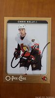 Front of signed Chris Kelly hockey card in Ottawa Senators uniform with autograph
