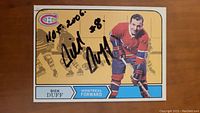 Front of the hockey card showing Dick Duff in Montreal Canadiens uniform, signed with black marker.
