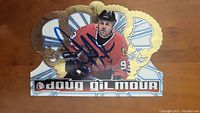 Front side of Doug Gilmour shaped hockey card with action shot and signature