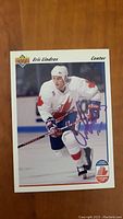Front of autographed Eric Lindros hockey card in Team Canada white jersey, skating with stick.
