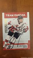 Front view of a John Tavares Team Canada hockey card with autograph in black ink across the player image.